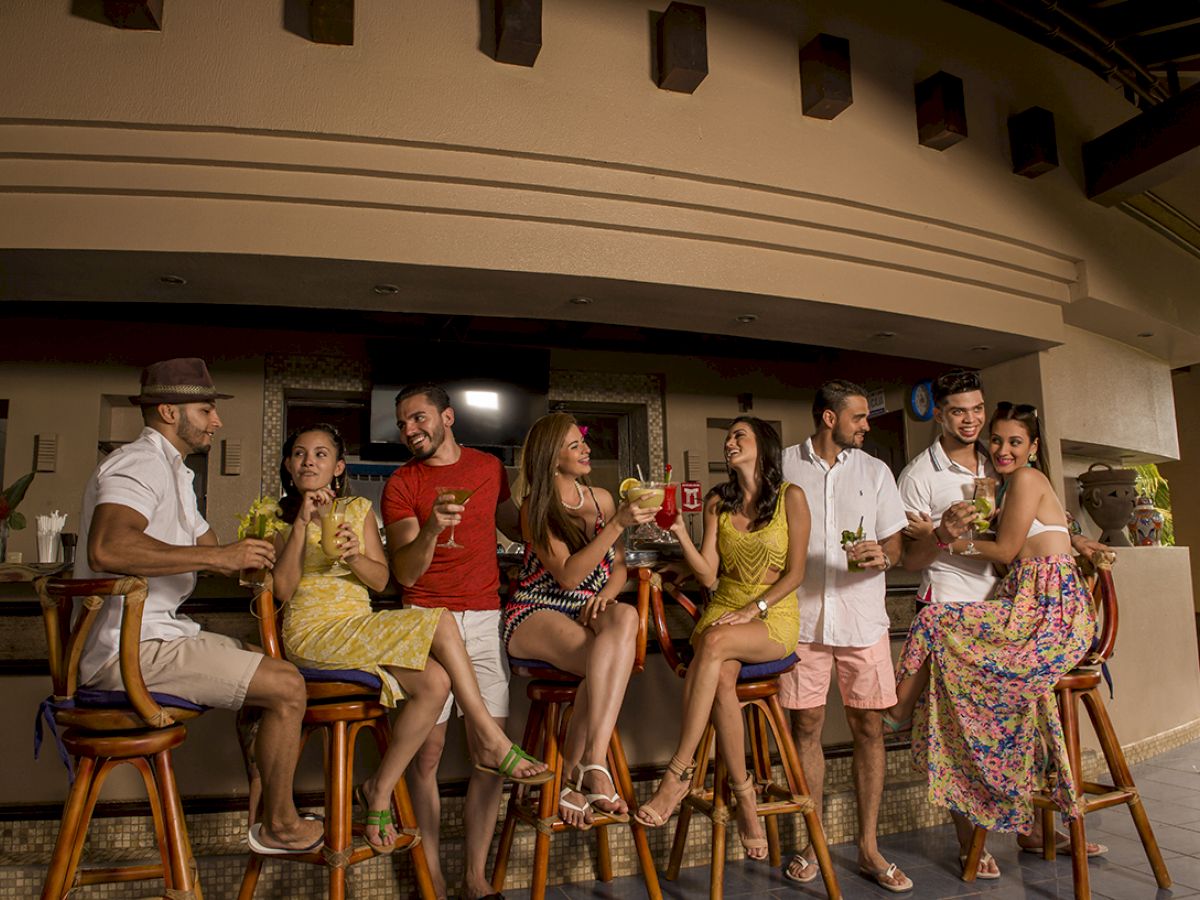 A group of people enjoy drinks together at a stylish bar, sharing laughter and conversation.