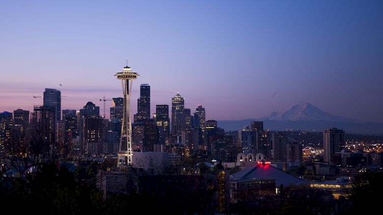 This image features the Seattle skyline at dusk, including the Space Needle and Mount Rainier in the background.